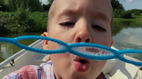 Adorable child blowing soap bubbles at camera in slow motion. Stock Footage 167971573