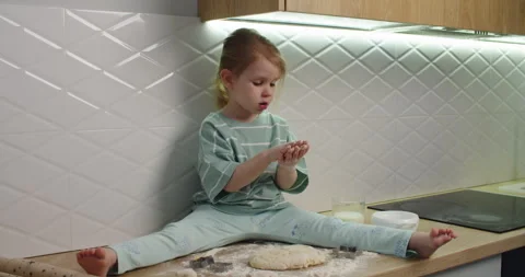 Adorable child practices splits while kneading dough Stock-Footage 333524061