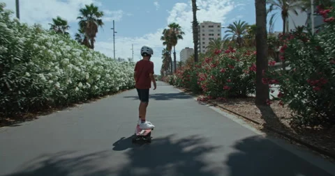 Adorable cute kid learn to ride longboard Stock Footage 254599745