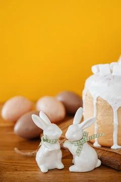 Adorable Easter bunny standing in front of a traditional Easter cake Stock Photos