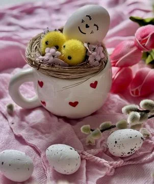 Adorable Easter Nest with Smiling Egg and Chicks in a Heart Mug Stock Photos
