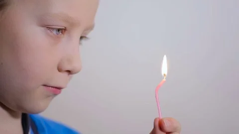Adorable eight year old boy blowing candle indoor. Slow motion. Stock Footage