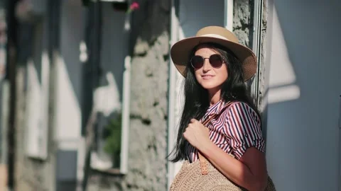 Adorable female posing surrounded by sunlight at cozy touristic place. Shot with Stock Footage 133628271