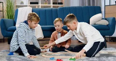 Adorable friendly different ages three brothers having fun together when Stock Photos