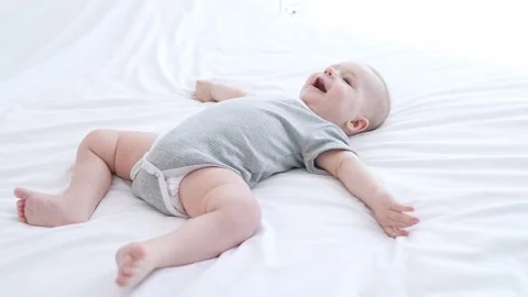 Adorable funny kid boy lying bed crib dry nappy enjoy recommend indoors Stock Footage 165676156