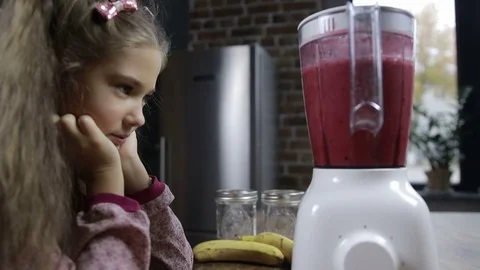 Adorable girl preparing fresh smoothie in blender Stock Footage