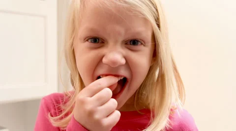 Adorable girl pulls her tooth and shows the camera Stock Footage 34003102