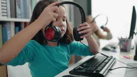 Adorable girls students using computer and headphones studying at classroom 스톡 동영상 241148975
