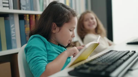 Adorable girls students using computer reading book at classroom 스톡 동영상 243998417