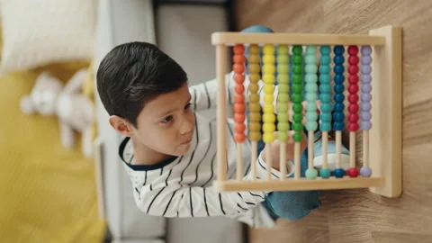 Adorable hispanic boy playing with abacus sitting on floor at home Stock Footage 230030355