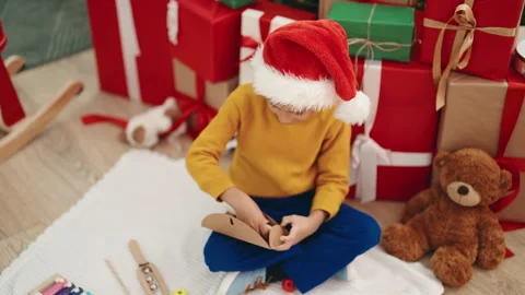 Adorable hispanic boy putting santa claus letter in envelope sitting by chr.. Video stock 230030331