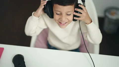 Adorable hispanic boy student using computer sitting on table at classroom 스톡 동영상 230939144