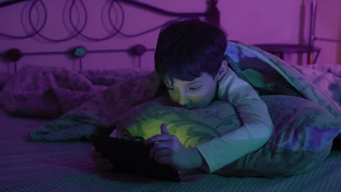 Adorable Kid Boy Using Digital Tablet Lying on Bed at Home Stock Footage 288576524