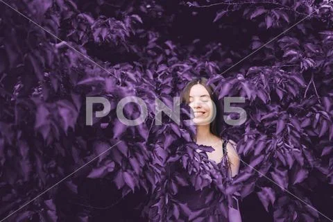 Adorable kid girl playing with blooming lilac flowers in spring garden, eyes Stock Photos