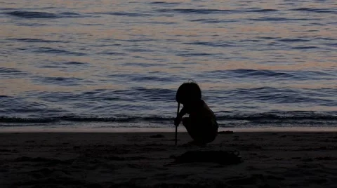Adorable Kid Playing with Sand on the Beach on Sunset Time. Видео 43819736