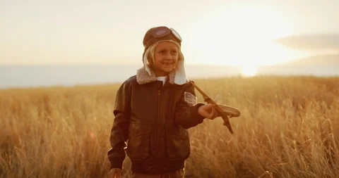Adorable kid wearing his flight suit and flying his wooden airplane Stock Footage 101398236