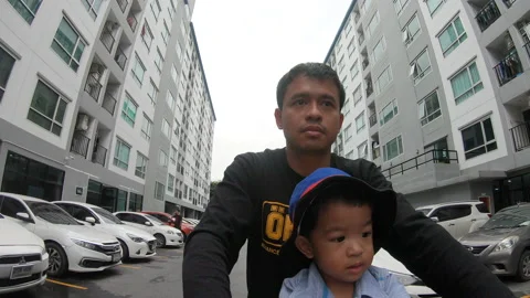 Adorable little boy sitting front of father on drive bicycle travel city Stock Footage 141379150