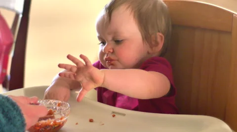 Adorable little girl eats spaghetti by herself for the first time, 4K Stock Footage 47078997