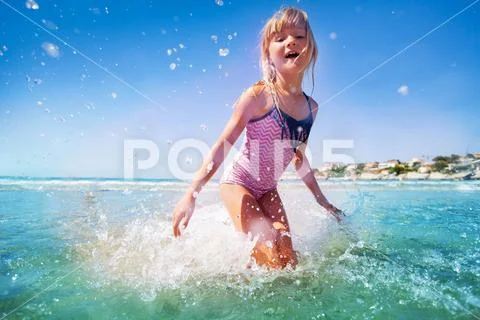 Adorable little girl having fun at shallow water Stock Photos