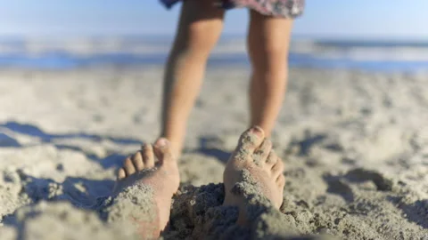 Adorable little girl kicking sand at adu... | Stock Video | Pond5