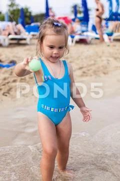 Adorable little girl standing on tropical beach Stock Photos