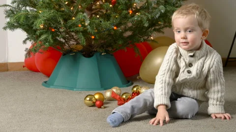 Adorable little smiling kid boy looking at camera near the christmas tree 库存影片 100873216
