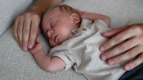 Adorable newborn sleeps on the bed holding hands up. Stock Footage 250574341