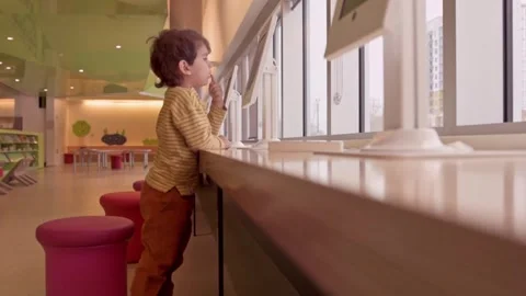 Adorable preschool boy playing touch screen application on tablet indoors Stock Footage 246135202