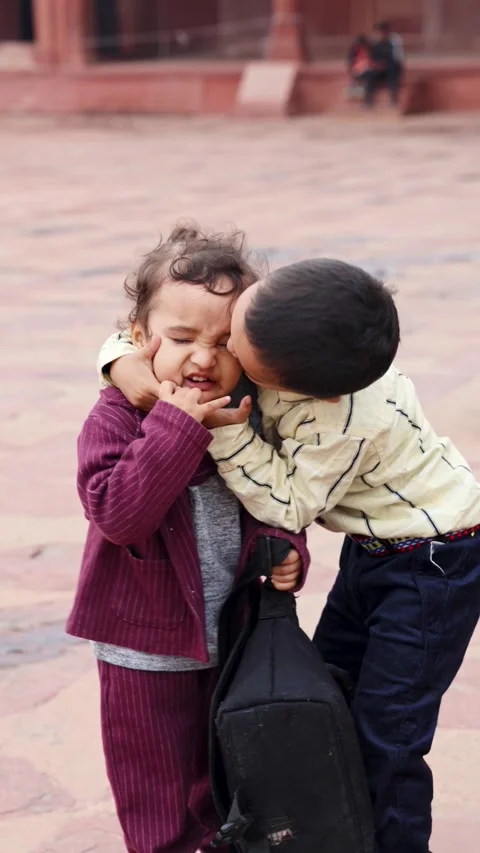 Adorable Sibling Affection Moment with Young Brother Kissing Toddler brothe.. Video stock 337565368
