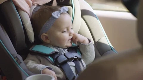 Adorable Smiley Baby Girl Sits In Her Car Seat, She Looks Out Window Stock Footage