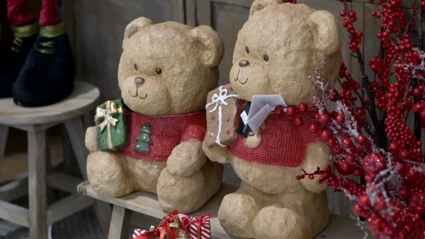 Adorable teddy bears in festive sweaters holding small gifts, surrounded by Video stock 321814905