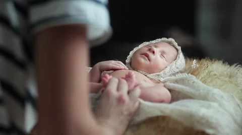Adorable tiny lying newborn baby angel being carefully wrapped into a warm knitt Stock Footage 50155526