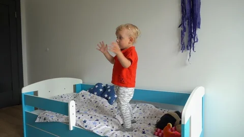 Adorable toddler boy jumping on new Stock Video Pond5