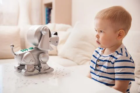 Adorable toddler boy playing with interactive toy. Child with toy robot dog.  Stock Photos