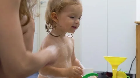 Adorable toddler boy taking a bath with mother. Stock Footage 284425812
