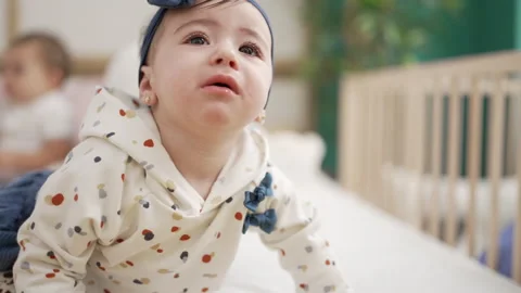 Adorable toddler crawling on bed crying pout at bedroom Stock Footage 221025727
