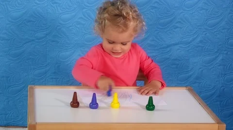 Adorable toddler girl with curly hair painting with crayons on paper sitting Stock Footage