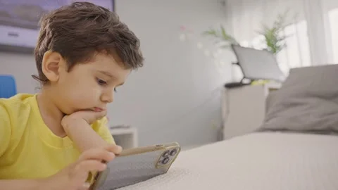 Adorable toddler watching educational apps on smartphone at home Stock Footage 246131330