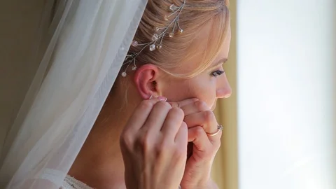 Adorable young bride is getting ready in the morning at home. The bride getting Видео 127572893