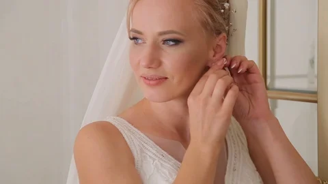 Adorable young bride is getting ready in the morning at home. The bride getting Stockbeeldmateriaal 127573096