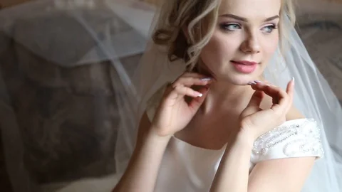 Adorable young bride is getting ready in the morning at home. The bride getting Stockbeeldmateriaal 127952323