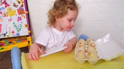 Adorable young kid carefully placing eggs into a carton. A cute boy actively Stock-Footage 330108914