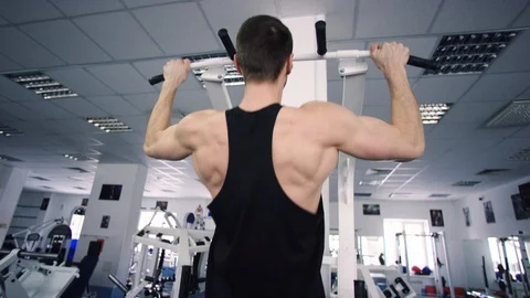 Adult athlete doing pull-ups exercise in a gym Stock Footage 105880915