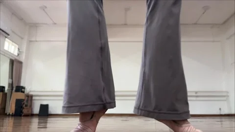 Adult Ballet Dancer Practicing Alternating Heel Raises in Studio 4K Stock Footage 345268586