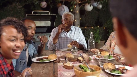 Adult black family eating outside at a dinner table Stock Footage