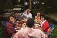 Adult Black Family Talking At Dinner In Their Garden Stock Photos