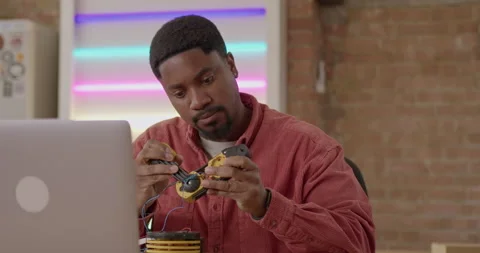 Adult Black male Engineer Developing Robot Technology in Workshop 動画素材 241830672