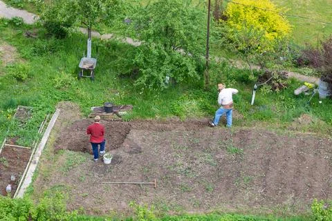 An adult couple is digging up their plot of land in the country for sowing .. Stockfoto's