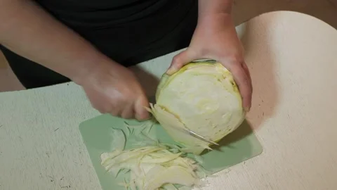 Adult hands slicing cabbage into thin shreds Stock Footage 342362731