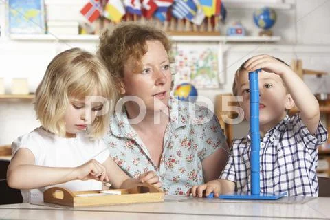 Adult Helping Two Young Children at Montessori/Pre-School Stock Photos